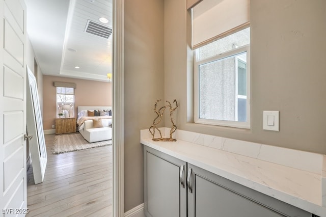 bathroom featuring wood finished floors, visible vents, and baseboards