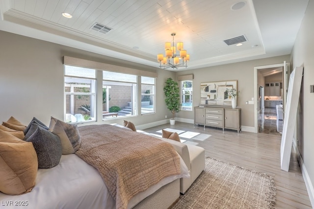 bedroom with light wood finished floors, baseboards, visible vents, and a raised ceiling