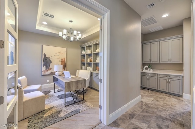 office space with baseboards, visible vents, and a tray ceiling