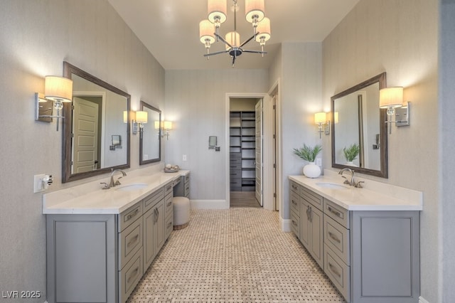 full bathroom featuring a walk in closet, two vanities, and a sink