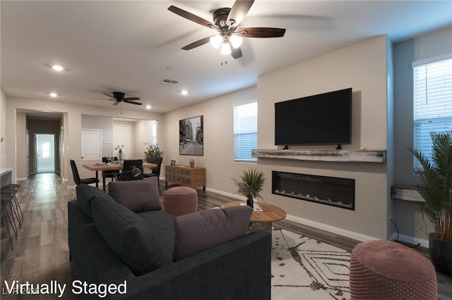 living room featuring ceiling fan and light hardwood / wood-style flooring