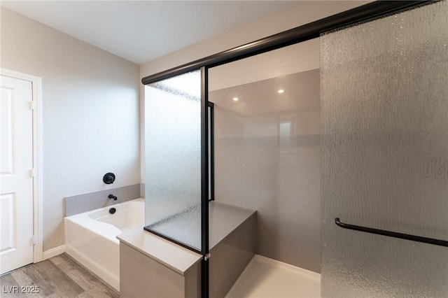 bathroom featuring hardwood / wood-style flooring and shower with separate bathtub