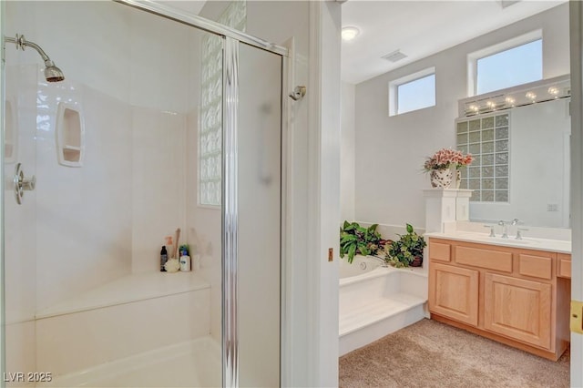 bathroom featuring vanity, a stall shower, a garden tub, and visible vents