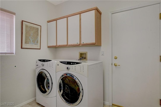 laundry room featuring washing machine and clothes dryer, cabinet space, and baseboards