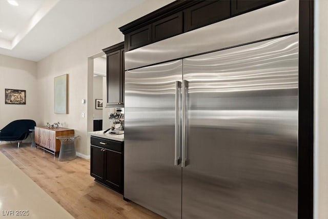 kitchen featuring built in fridge and light wood-type flooring