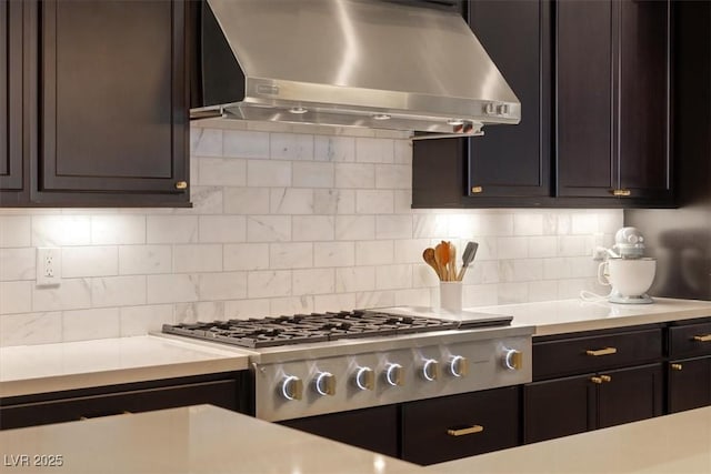 kitchen featuring backsplash, ventilation hood, and range