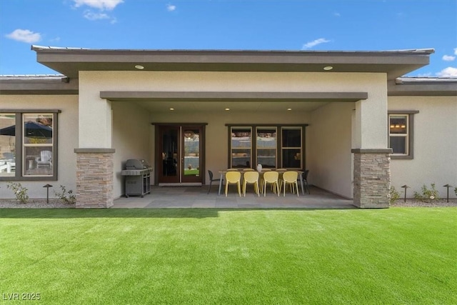 back of property featuring a patio and a lawn