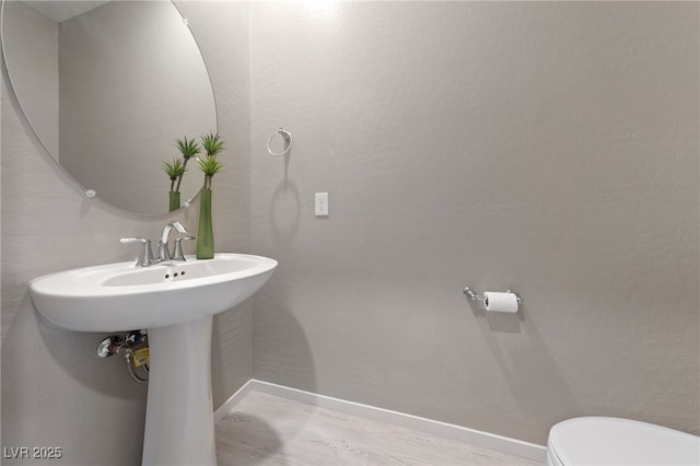 bathroom with toilet and hardwood / wood-style floors