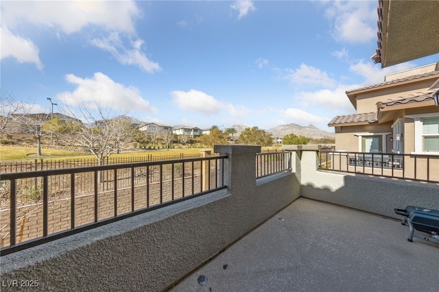 view of patio with a balcony and a mountain view