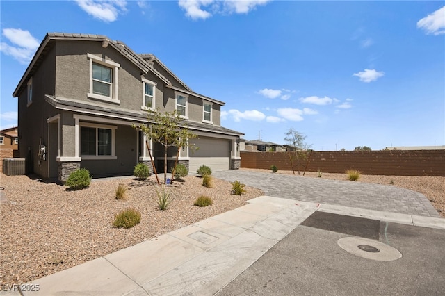 view of front of property featuring a garage and central air condition unit