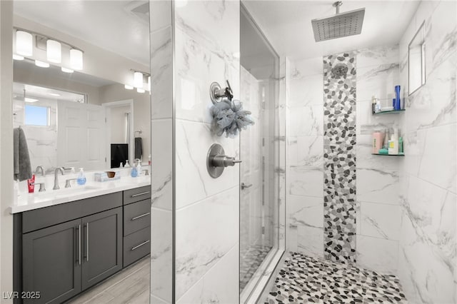 bathroom with vanity and a tile shower