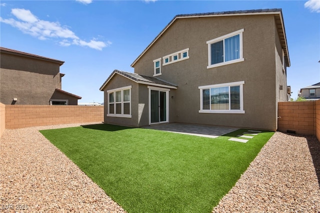 back of house featuring a lawn and a patio area