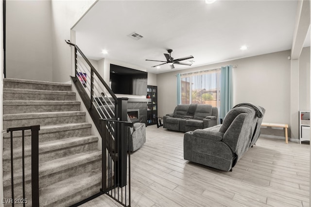 living room with ceiling fan and light wood-type flooring