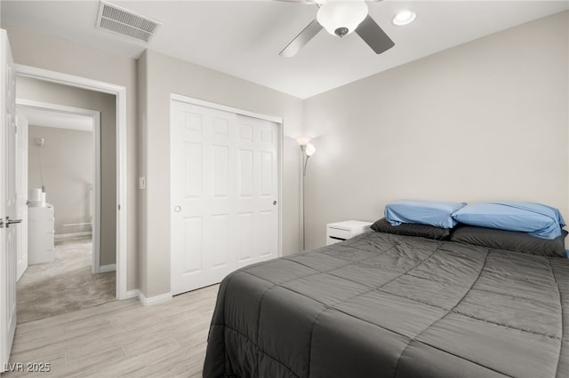 bedroom featuring ceiling fan, light hardwood / wood-style floors, and a closet