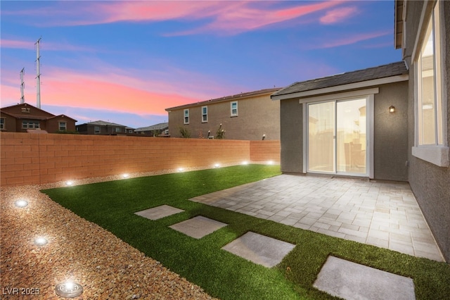 yard at dusk featuring a patio area