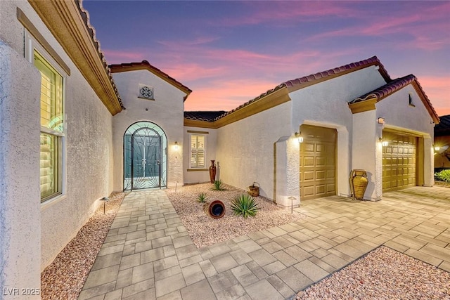 exterior entry at dusk with a garage