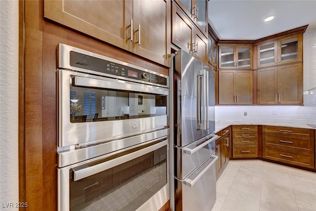 kitchen featuring tasteful backsplash, stainless steel appliances, and light tile patterned floors