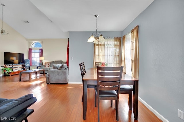 dining room featuring baseboards, wood finished floors, visible vents, and a notable chandelier