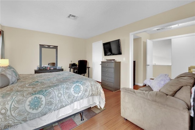 bedroom with visible vents and wood finished floors