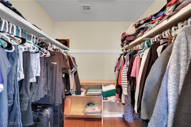 walk in closet with visible vents and wood finished floors