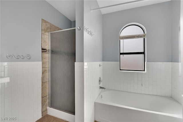 full bathroom featuring a garden tub, tile patterned flooring, a shower stall, and tile walls