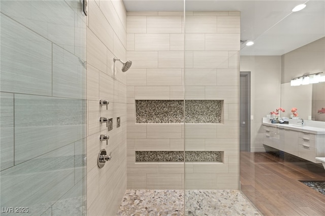 bathroom with vanity and a tile shower