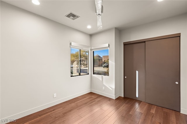 unfurnished bedroom with wood-type flooring and a closet