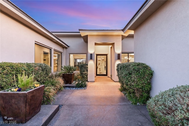 exterior entry at dusk featuring a patio area