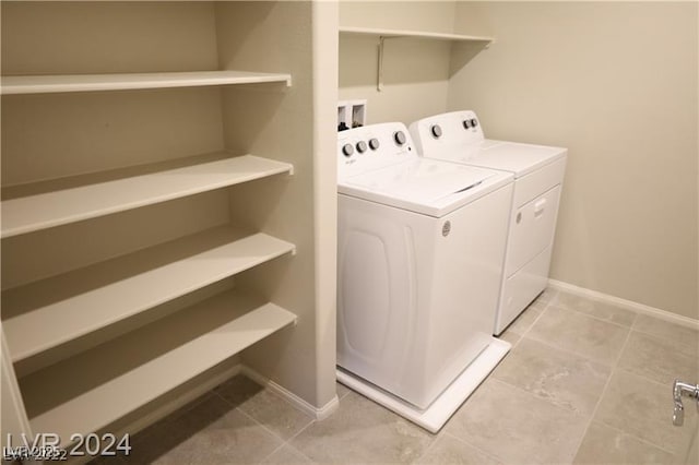 washroom with light tile patterned floors and washer and dryer