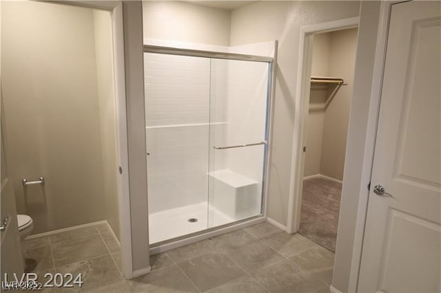 bathroom with tile patterned floors, toilet, and walk in shower