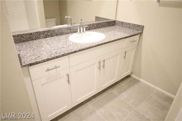 bathroom with tile patterned flooring, vanity, and toilet