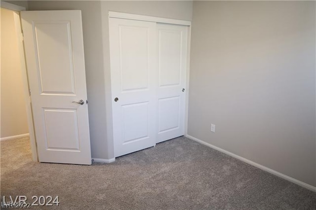 unfurnished bedroom with carpet floors and a closet