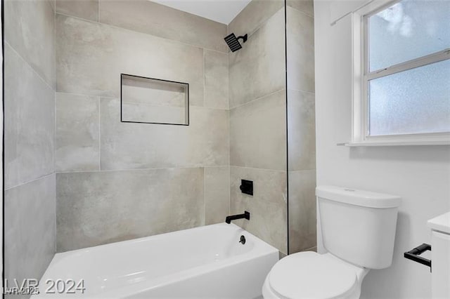 bathroom featuring tiled shower / bath and toilet