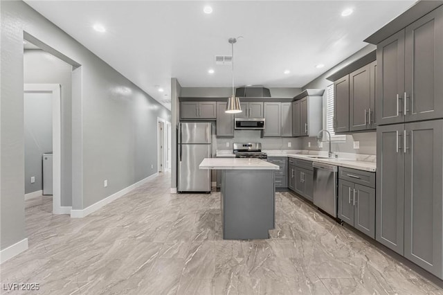 kitchen featuring sink, hanging light fixtures, gray cabinets, a kitchen island, and stainless steel appliances