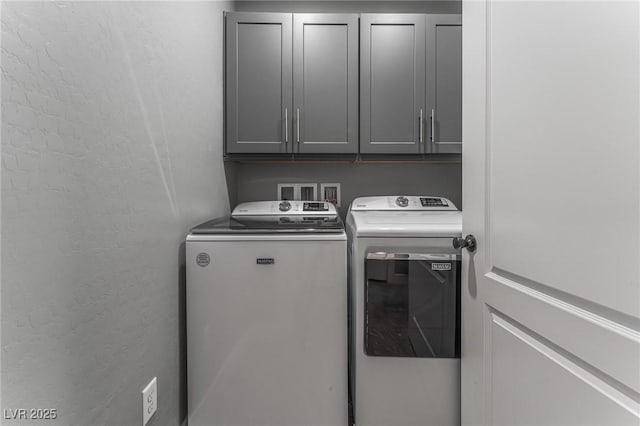 laundry room featuring cabinets and washer and dryer