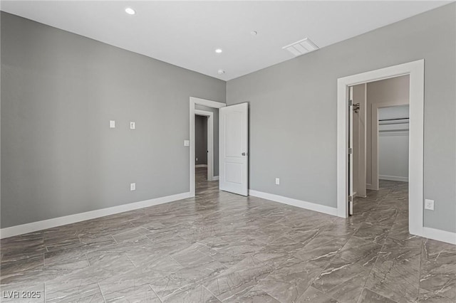 unfurnished bedroom featuring a walk in closet