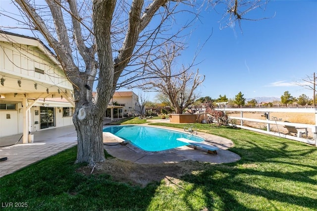 pool with a lawn, a patio, a jacuzzi, fence, and a diving board