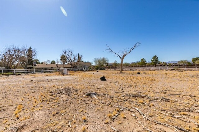 view of yard with fence and a rural view