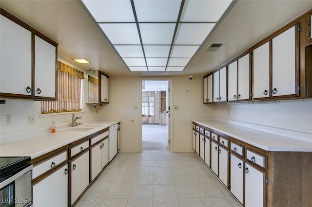 kitchen featuring white cabinets, visible vents, light countertops, and a sink