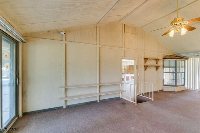 carpeted spare room featuring vaulted ceiling and a ceiling fan