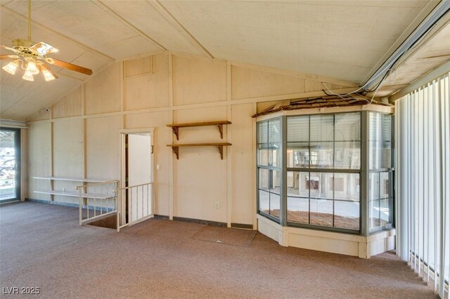 carpeted empty room featuring vaulted ceiling and ceiling fan