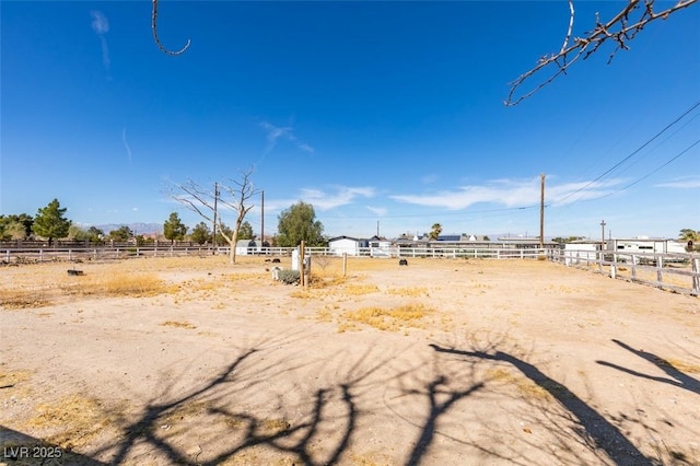 view of yard with a rural view, an enclosed area, and fence