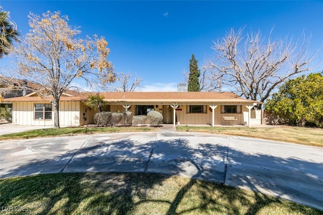 ranch-style home with driveway and board and batten siding