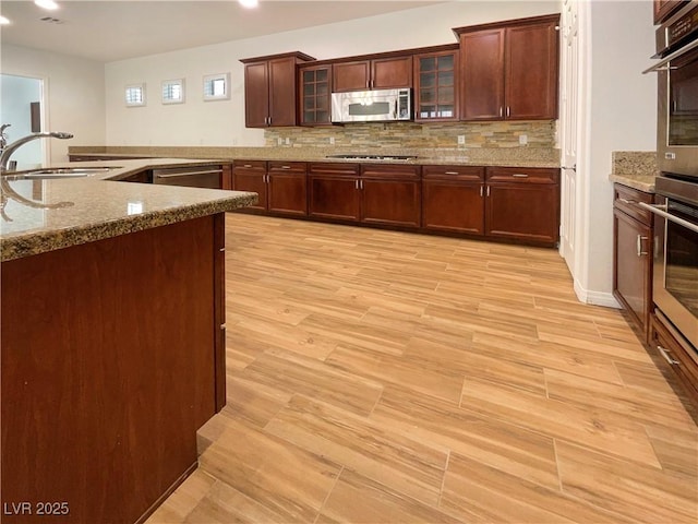 7719 Windy Meadow Ave, Las Vegas, NV 89178 - kitchen with stainless steel appliances, a sink, decorative backsplash, dark stone countertops, and recessed lighting