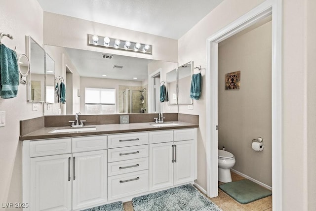 full bathroom with a sink, a shower stall, toilet, and double vanity