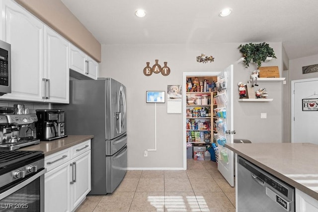 kitchen featuring appliances with stainless steel finishes, recessed lighting, white cabinets, and light tile patterned floors