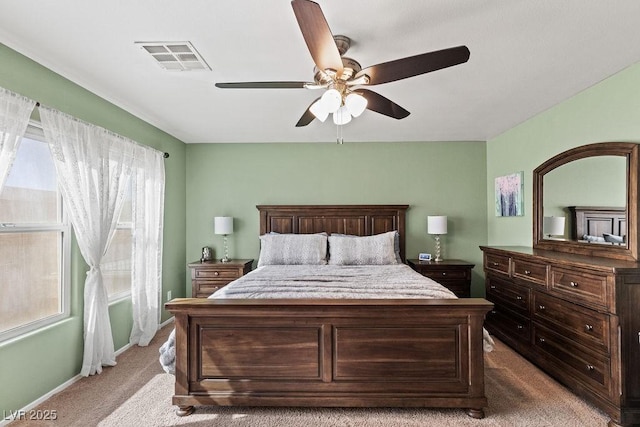 bedroom featuring baseboards, visible vents, a ceiling fan, and light colored carpet