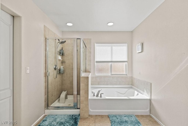 bathroom featuring a garden tub, tile patterned flooring, baseboards, and a shower stall