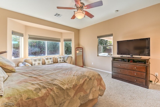 carpeted bedroom with ceiling fan and multiple windows