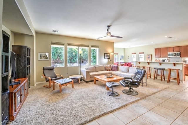 living room with light tile patterned floors and ceiling fan